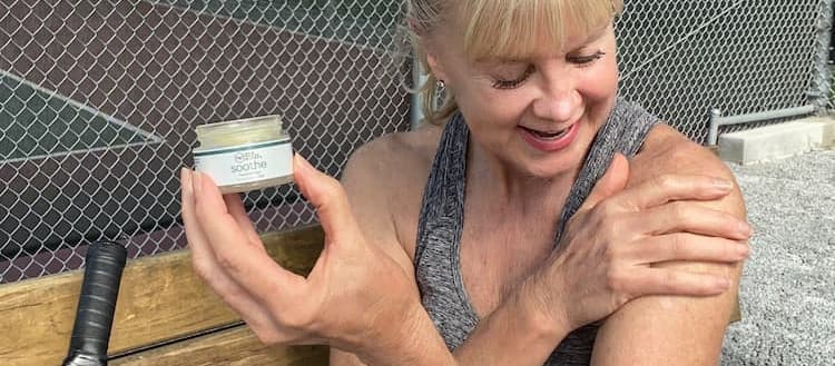 applying CBD cream on shoulder